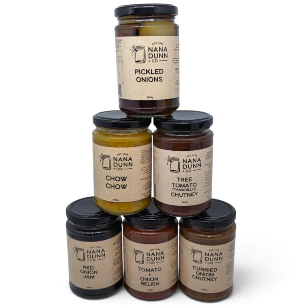 Six Nana Dunn + Co jars stacked in a pyramid: Pickled Onions, Chow Chow, Tree Tomato (Tamarillo) Chutney, Red Onion Jam, Tomato + Onion Relish and Curried Onion Chutney