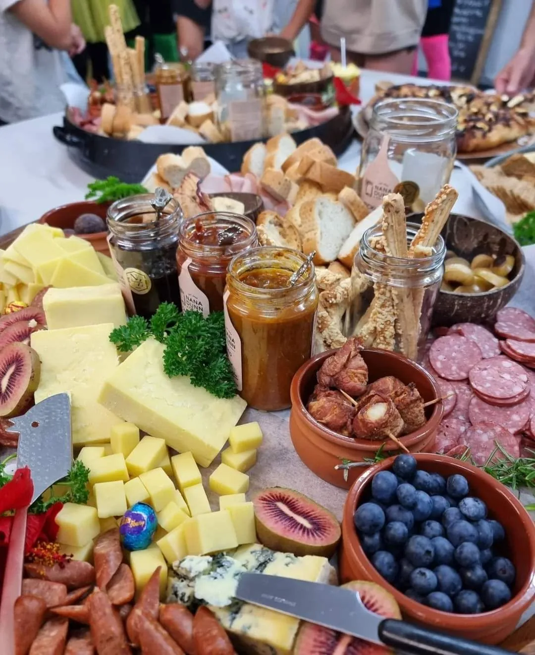Nana Dunn jars on a shared platter with cheese, bread and salami